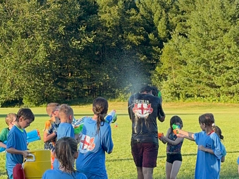 Campers and coaches in a water-gun battle